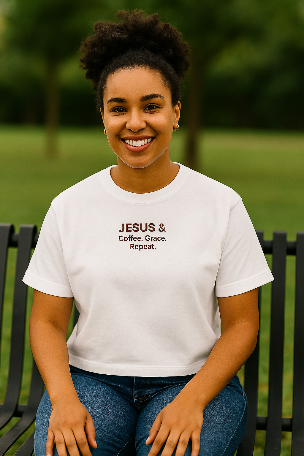 Woman wearing a white t-shirt with 'Jesus & Coffee, Grace, Repeat.' text in a park setting