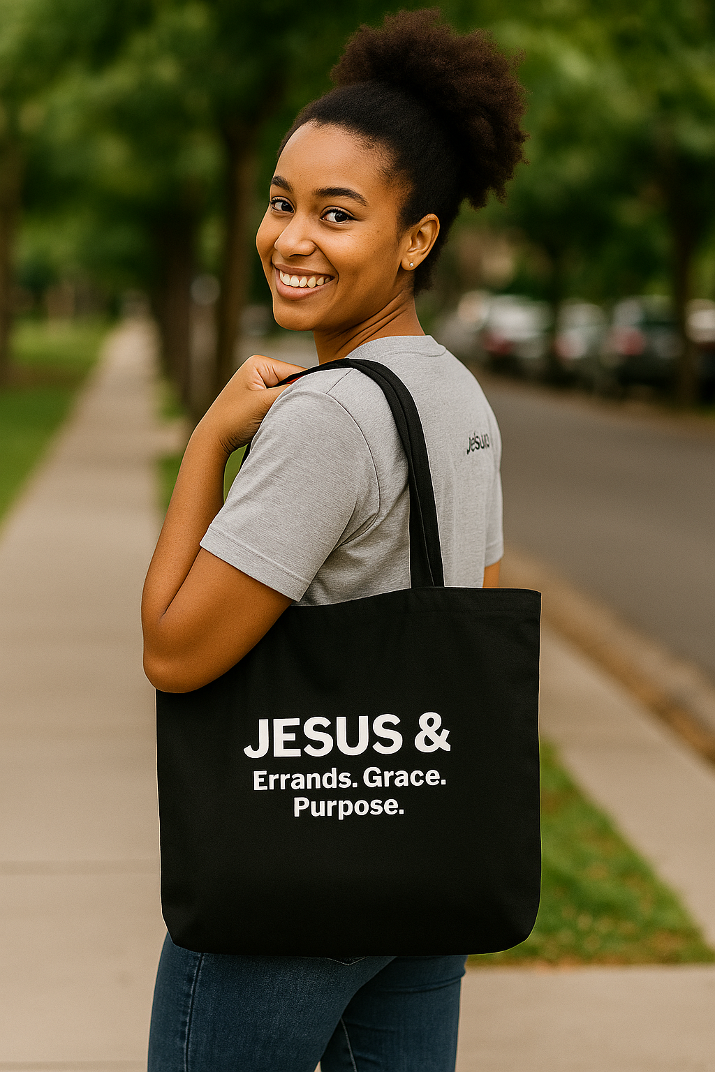 Woman carrying a black tote bag with Jesus & on a sidewalk