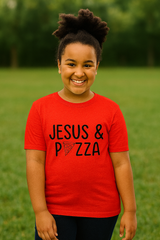 Child wearing a red shirt with 'Jesus & Pizza' text in a grassy outdoor setting